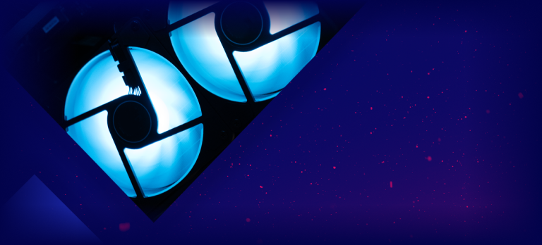 A triangular section of two glowing blue circular lights set against a dark, starry, purple background with scattered red specks.