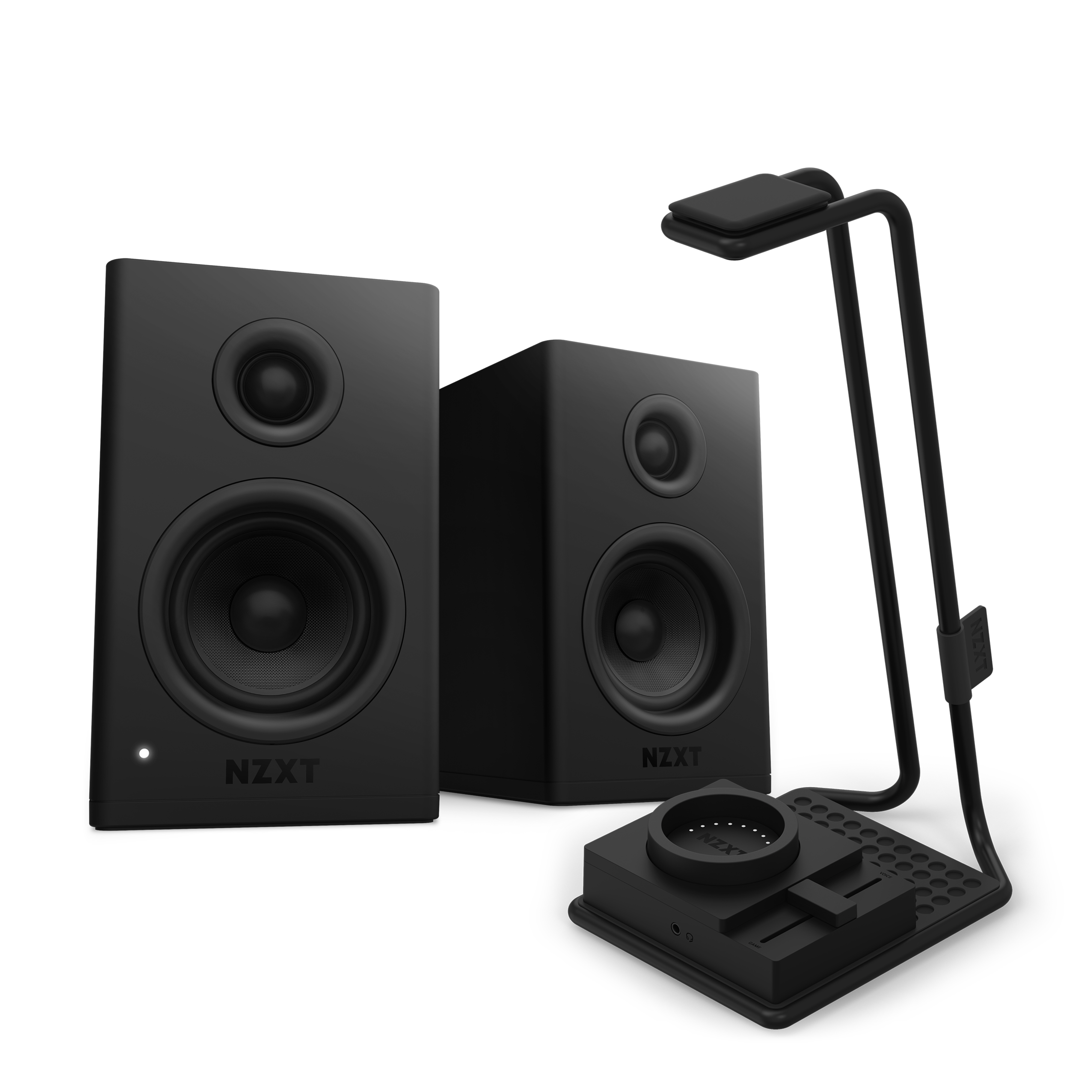 Two black NZXT Relay Speakers + SwitchMix with circular drivers are placed beside a sleek black desk organizer with a lamp and wireless charging pad, delivering high-resolution audio against a dark background.