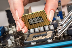 A person installing a processor into a motherboard.