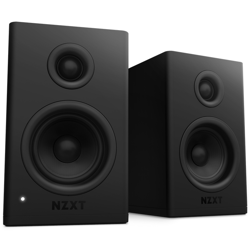 Two black NZXT Relay Speakers featuring circular glass fiber woofers are placed side by side on a black background. One speaker displays a small white indicator light at its bottom left corner.